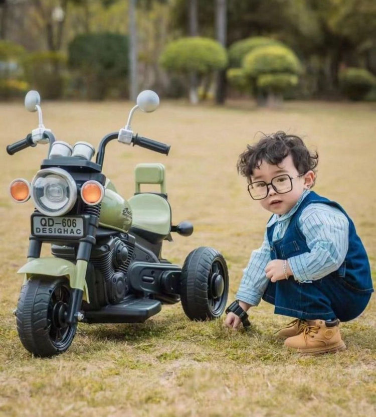 Toddler boy playing outdoors with a green toy motorcycle from toy shop near me Sam's World Ahmedabad Gujarat