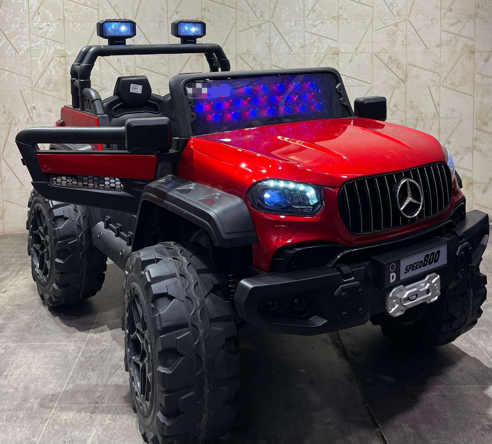 Red battery operated children's car make in Ahmedabad Gujarat with off-road tires and LED lights