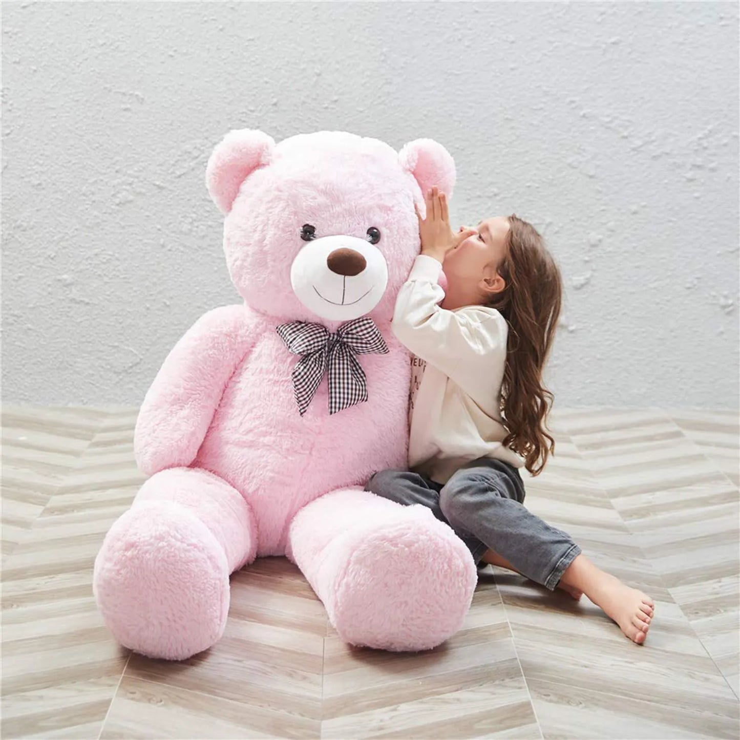 Big size soft plush teddy for girls Ahmedabad Gujarat India shown with a little girl sitting beside a large pink teddy bear