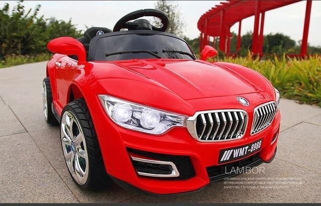 Red children's ride on car with remote control featuring realistic headlights and shiny black wheels