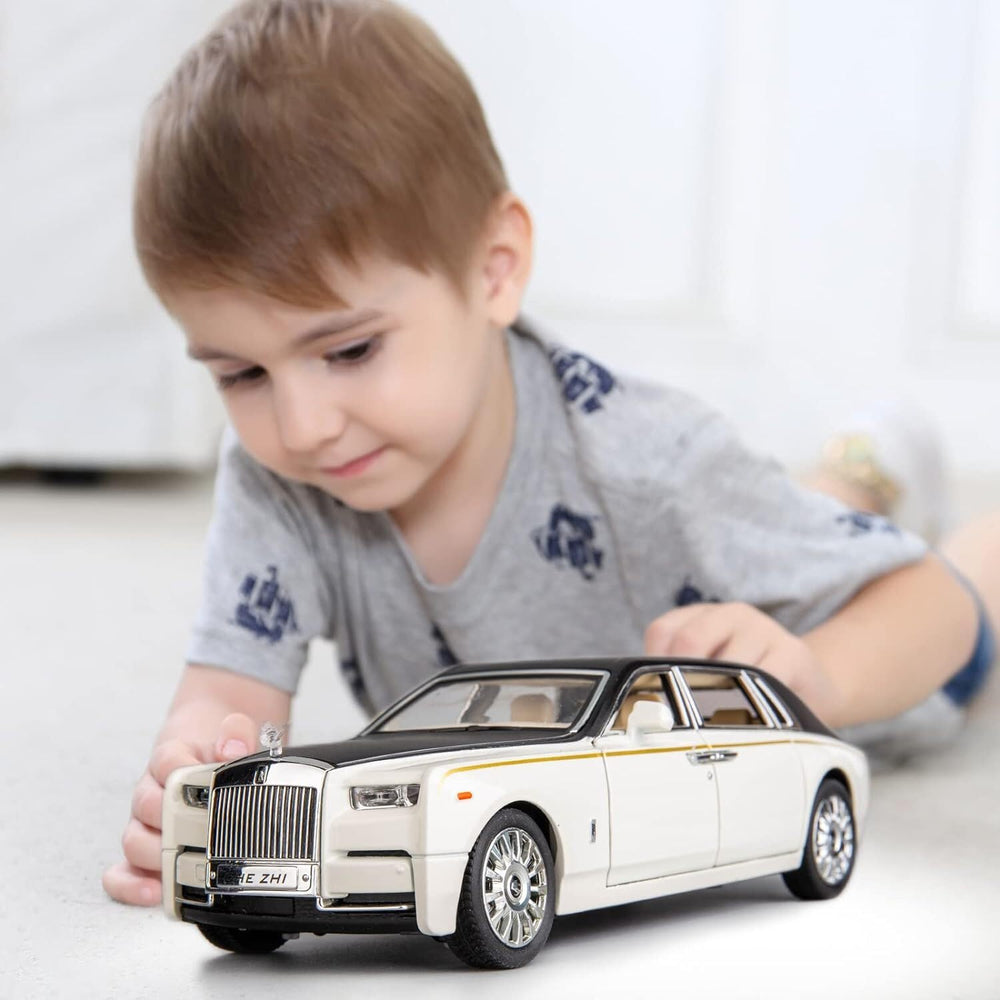 Young boy playing with white and black Rolls Royce Phantom diecast model car with lights and music. Toy by samstoy.in