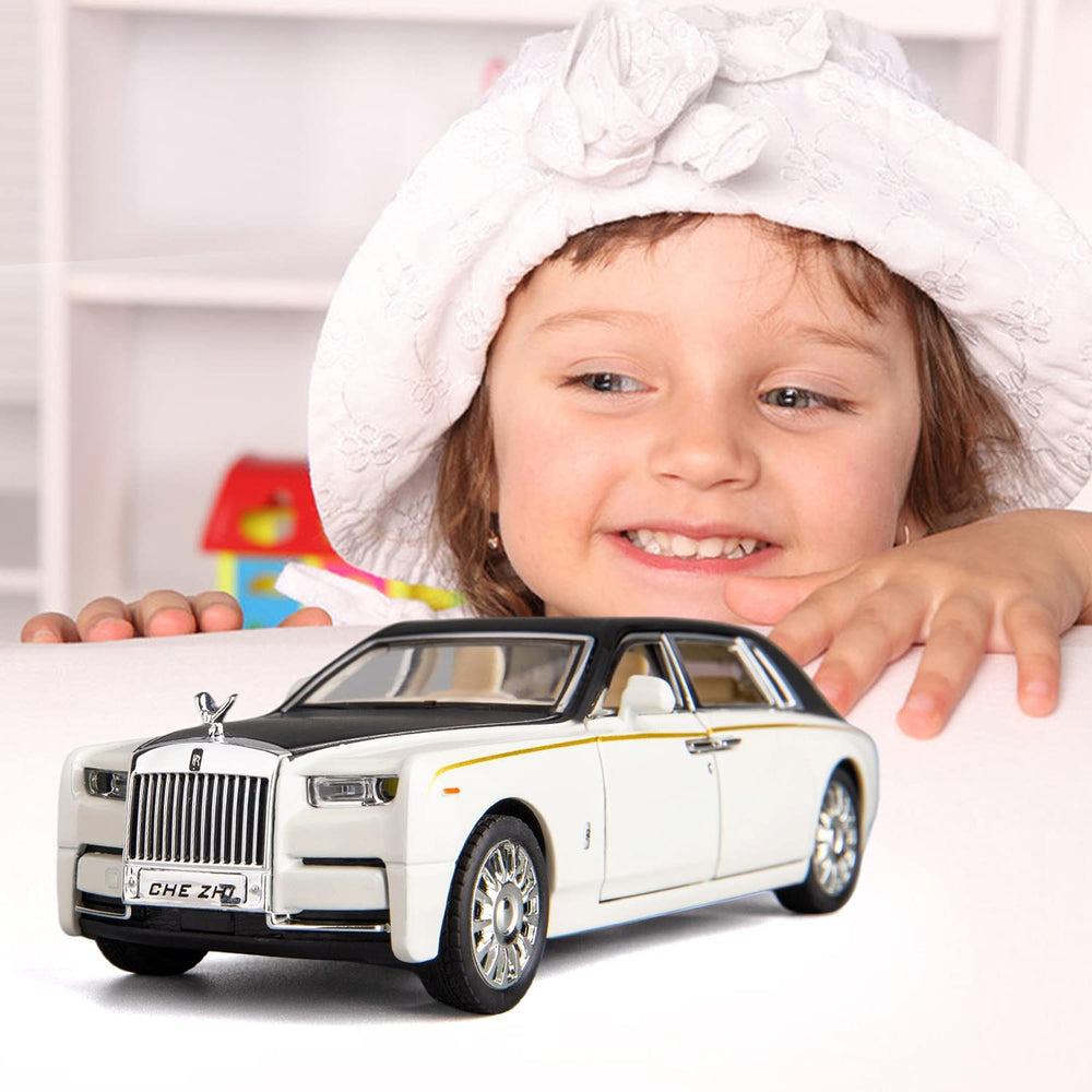 Child playing with white Rolls Royce Phantom diecast model car with lights and music. Toy model on table