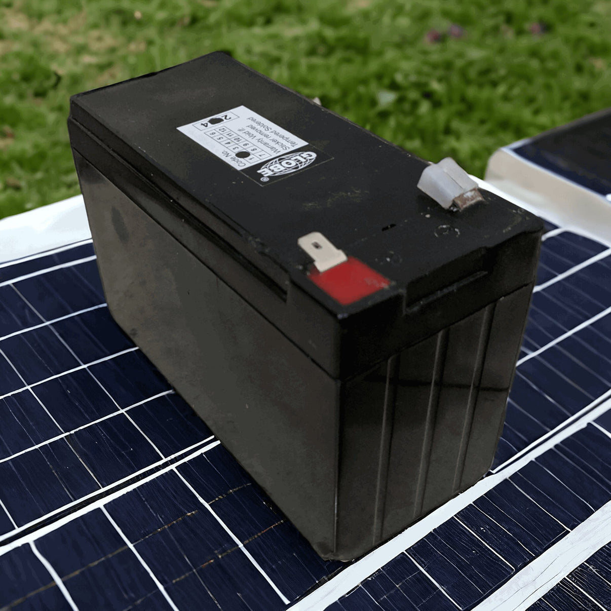 Buy 12V rechargeable battery for kids ride-on cars Ahmedabad Gujarat black rectangular battery on solar panel