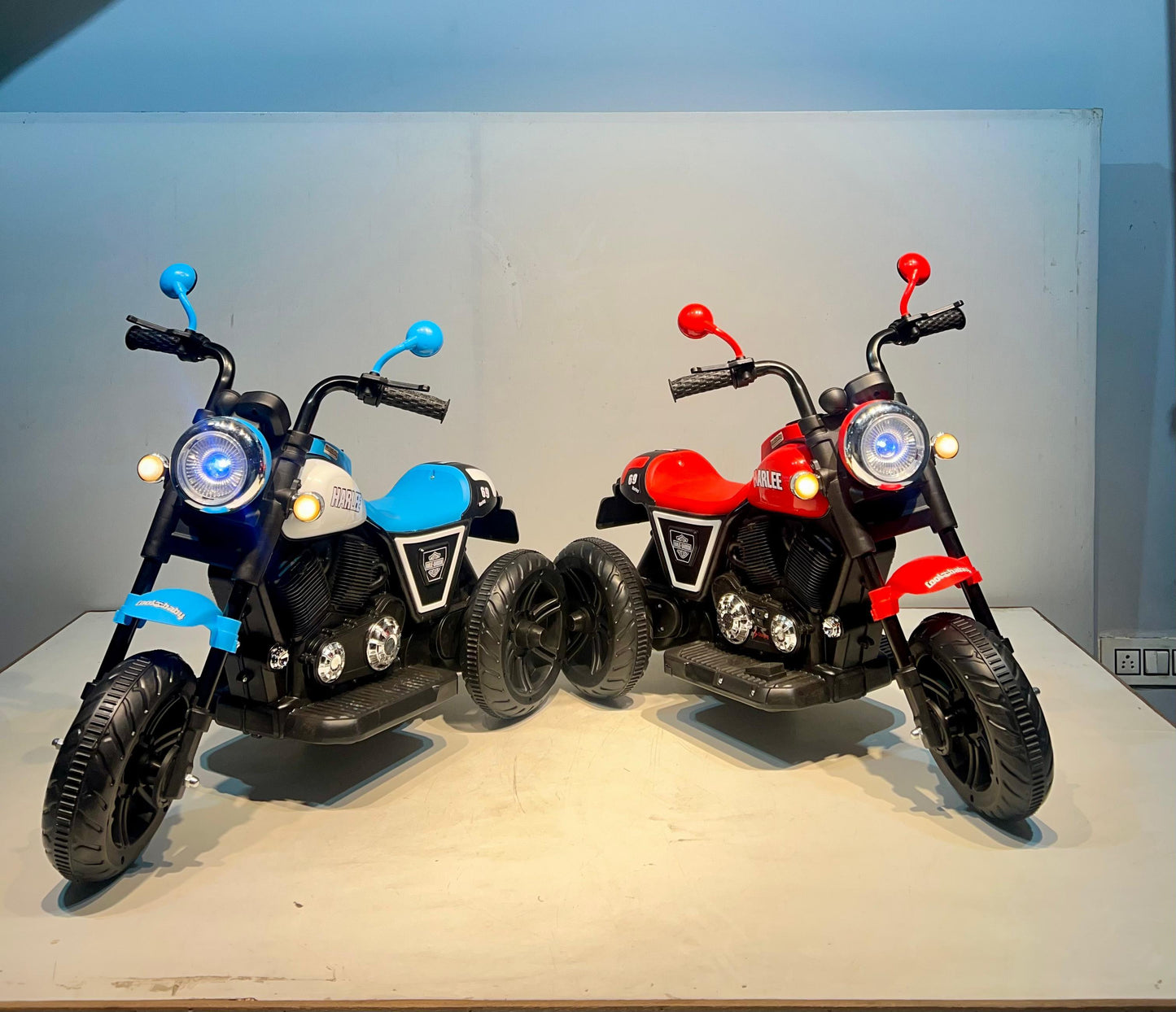 Two rechargeable kids bike Ahmedabad Gujarat models in blue and red with realistic motorcycle design and headlight
