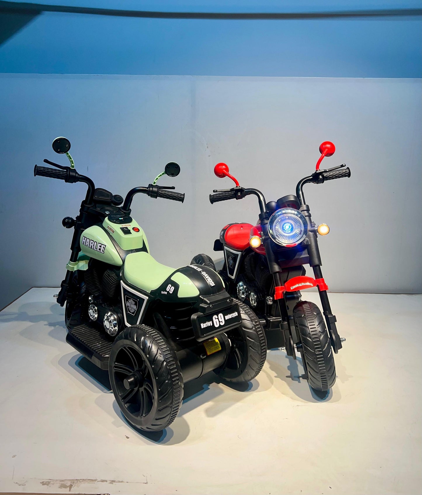Rechargeable kids bike Ahmedabad Gujarat featuring two child electric motorcycles in green and red colors