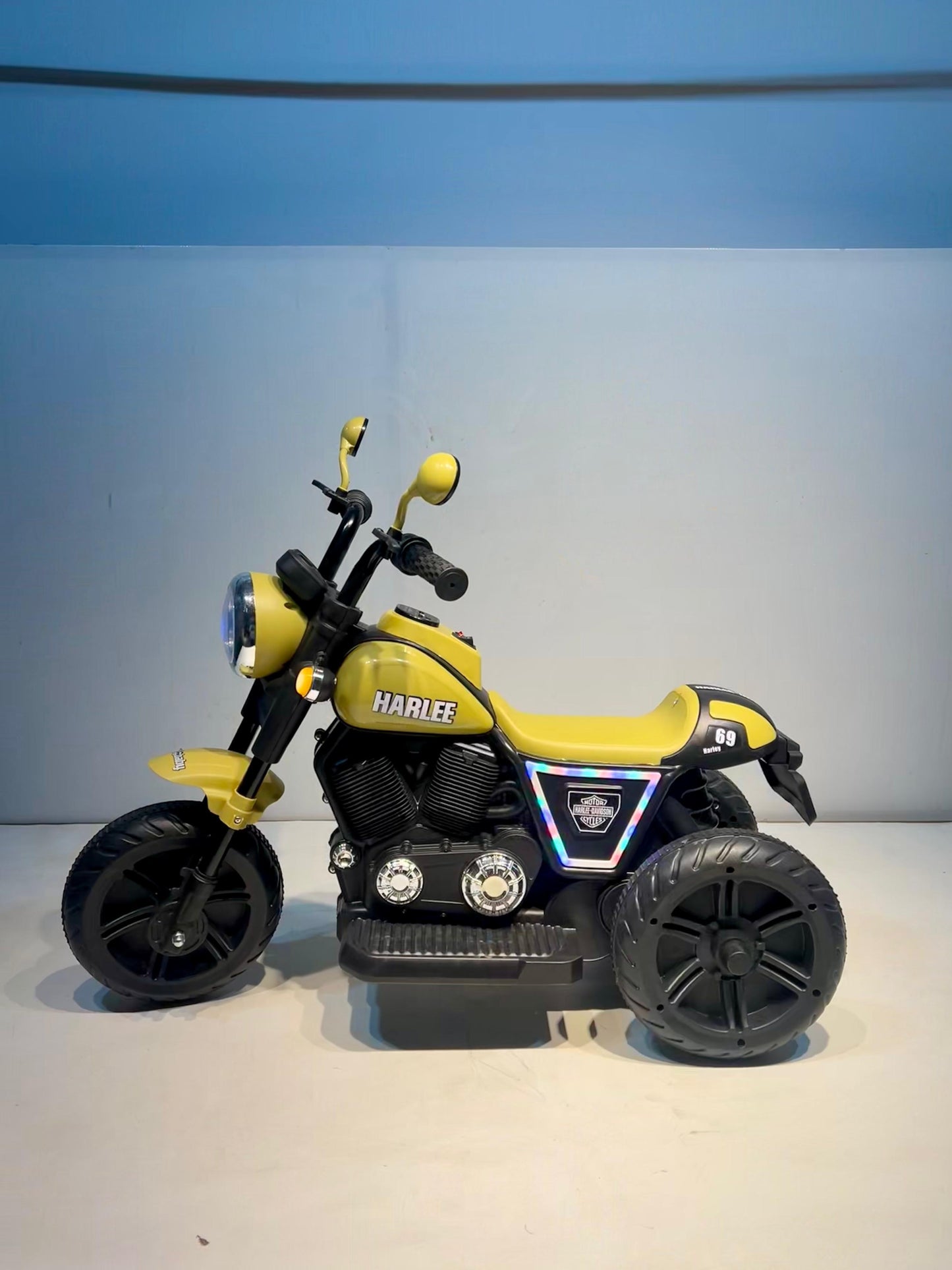 Yellow rechargeable kids bike Ahmedabad Gujarat styled like a motorcycle with three wheels and black accents