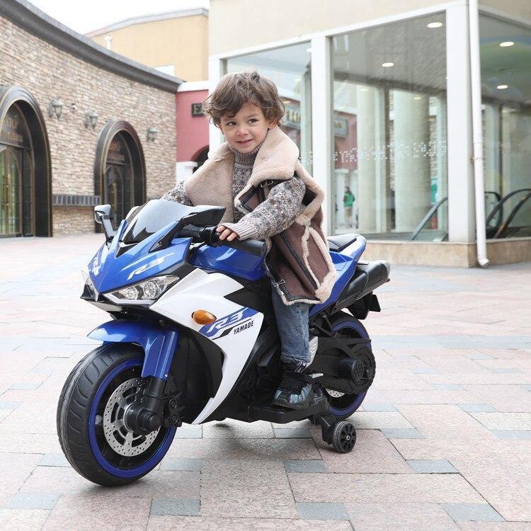 Child riding a blue Yamaha style rechargeable ride-on bike 2-10 years Sam’s Ahmedabad Gujarat with training wheels outdoors
