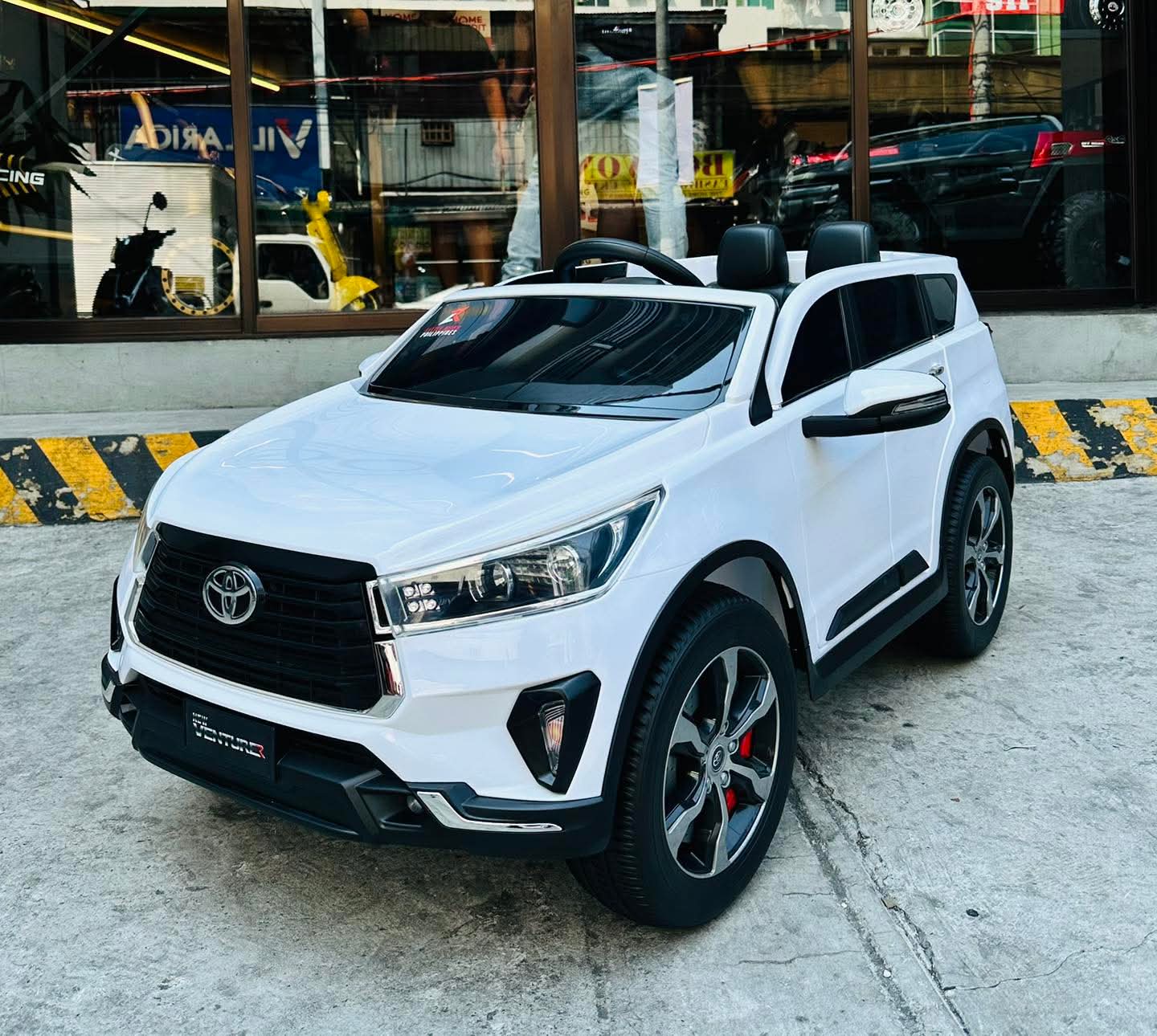 White 2026 Toyota Innova battery operated ride-on car with sleek design and sporty wheels