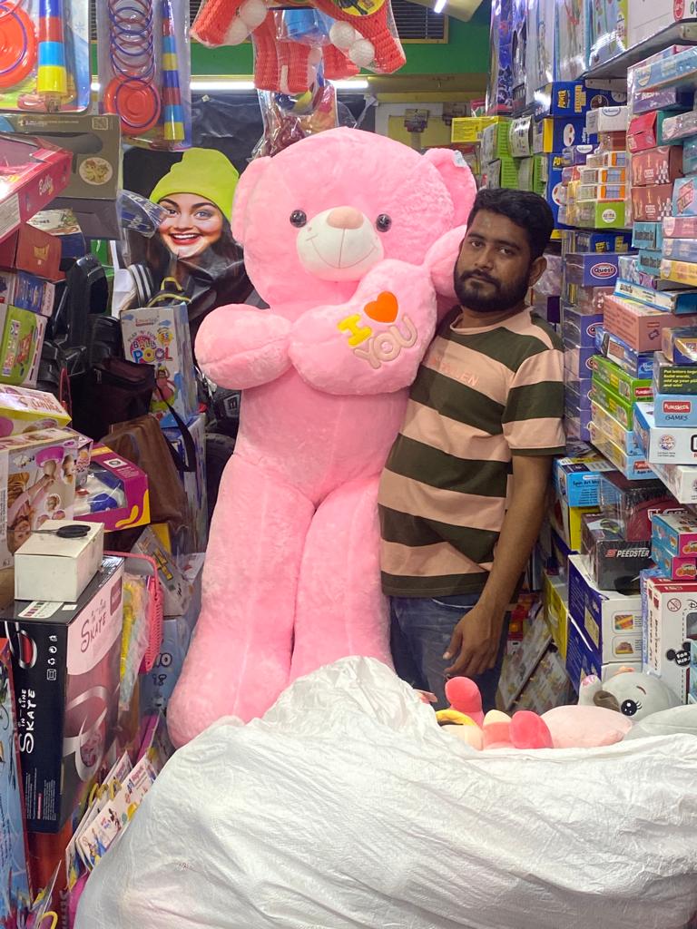 Samstoy in big pink plush teddy held by store clerk in crowded toy aisle big teddy bear In Ahmedabad Gujarat online India