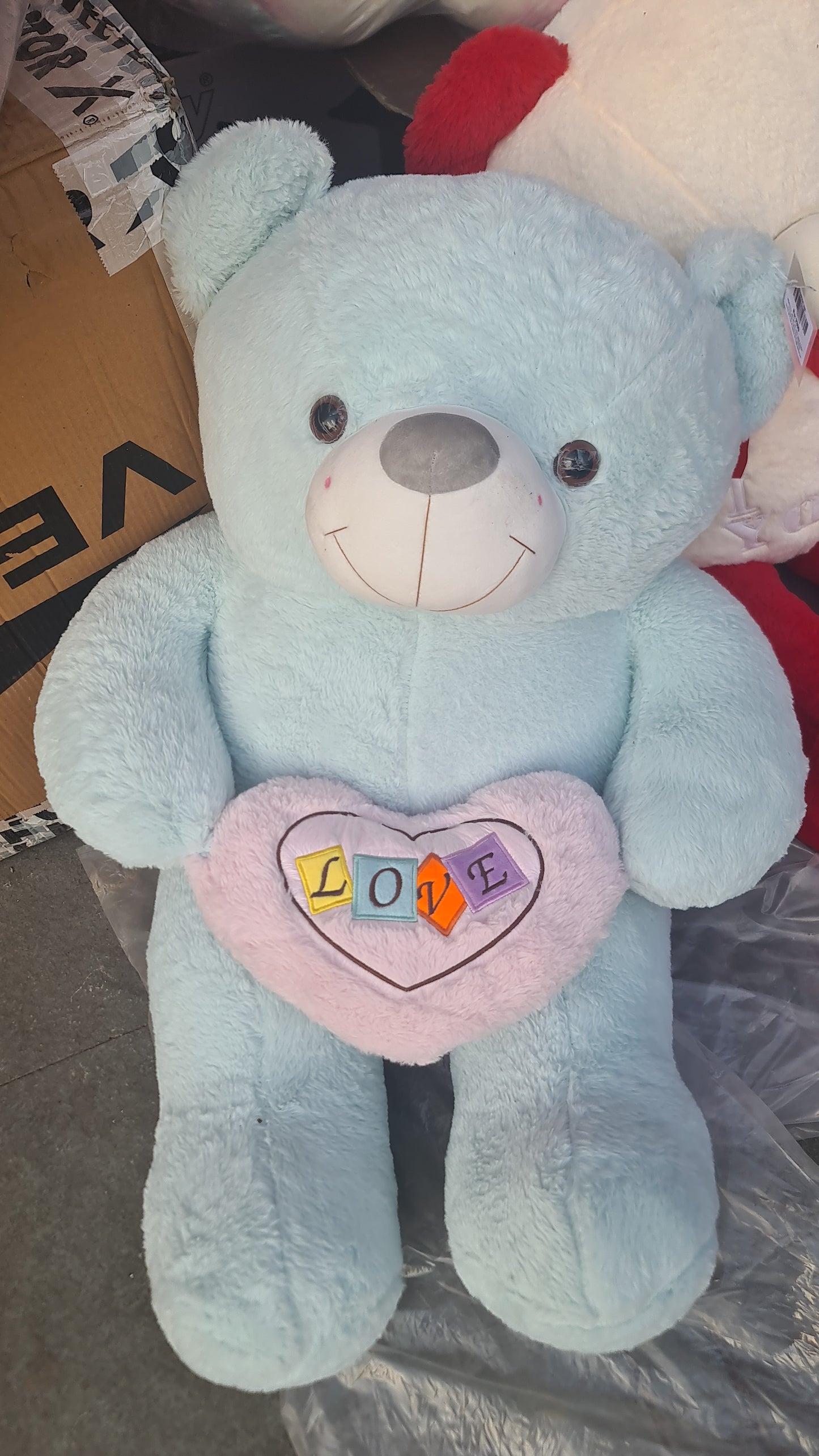 Light blue plush big teddy bear In Ahmedabad Gujarat online India holding a pink heart with LOVE letters from samstoyin