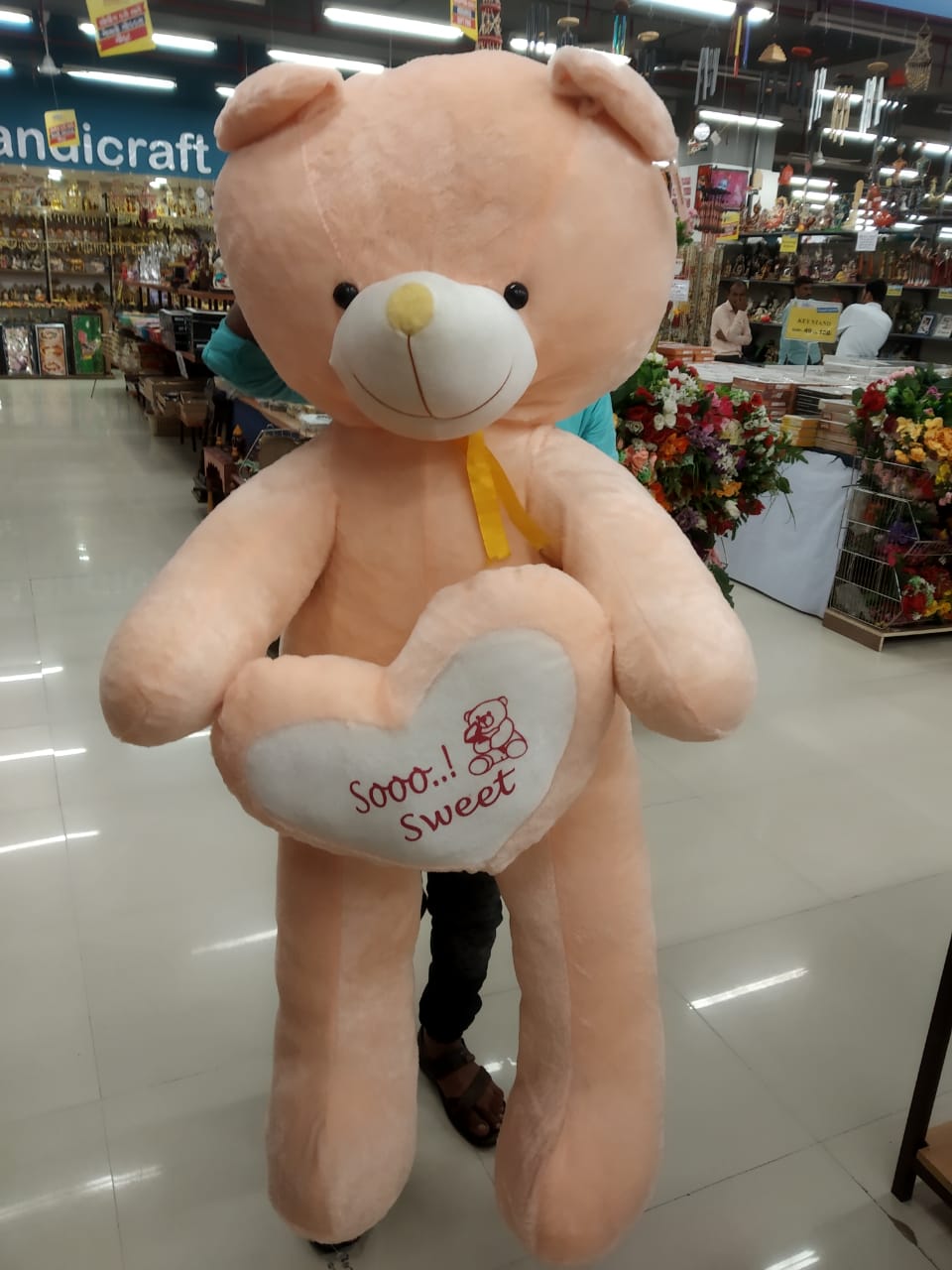 Large peach plush teddy bear holding heart pillow in store big teddy bear In Ahmedabad Gujarat online India