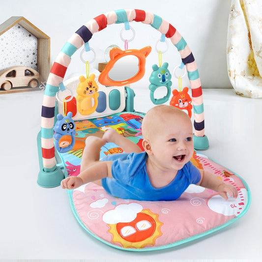 Baby lying on colorful baby play mat with piano keyboard and hanging animal toys for sensory play