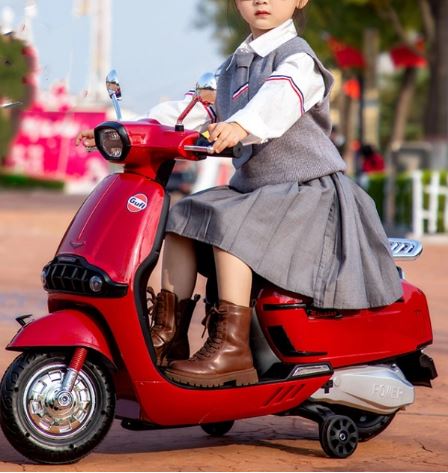 Child riding a red Battery Gulf scooter for kids Ahmedabad Gujarat in a park setting