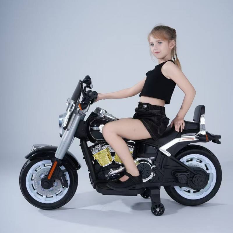 Girl sitting on black battery operated bike for kids Ahmedabad with training wheels and realistic design