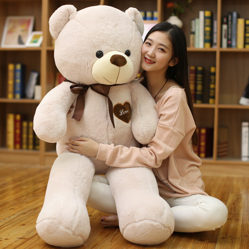Young woman hugging a big large teddy bear with love heart patch to buy big large teddy bear online Ahmedabad