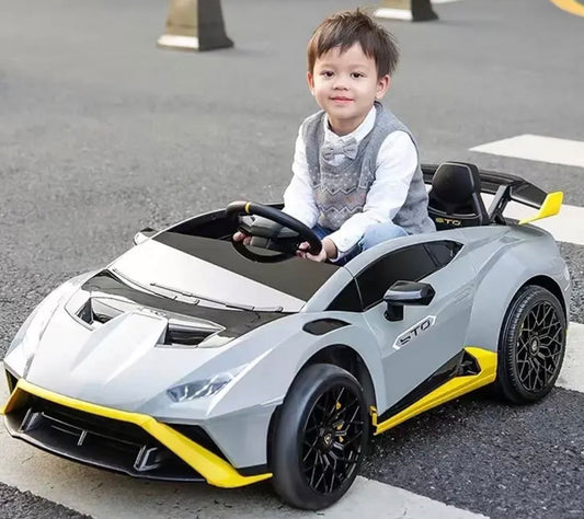 Gray childs electric ride on car with yellow accents, side view, perfect for outdoor play.