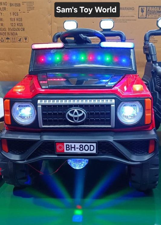 Red childs ride on jeep in Ahmedabad with colorful lights, front view, for outdoor fun and play