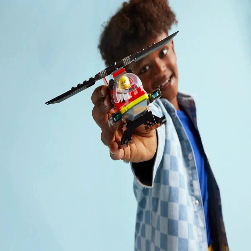 Child holding LEGO City Fire Rescue Helicopter 60411 Ahmedabad Gujarat India toy with pilot in bright blue background