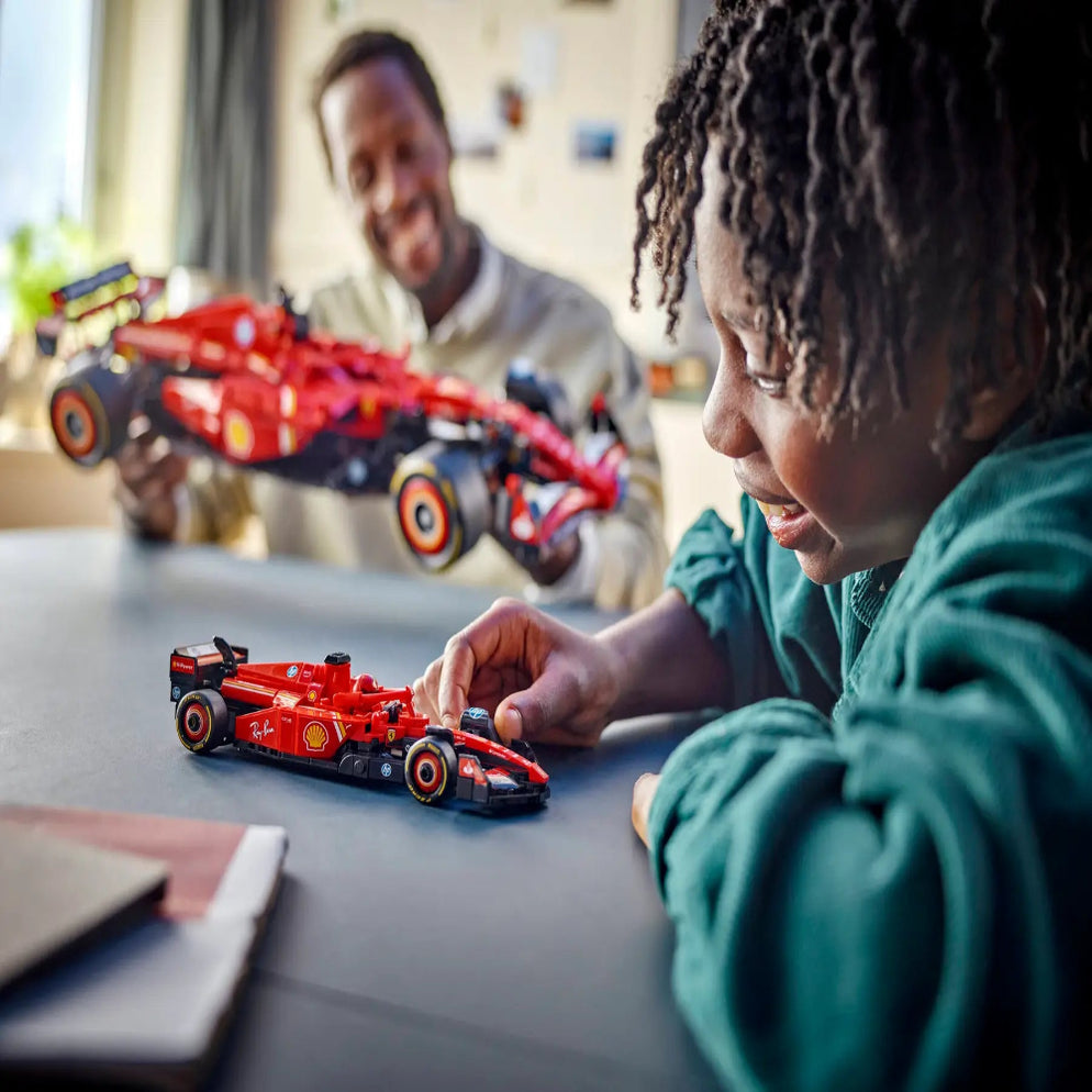 Child playing with LEGO Technic Ferrari SF-24 F1 car in Gujarat online India . Red Technic F1 model on table with parent