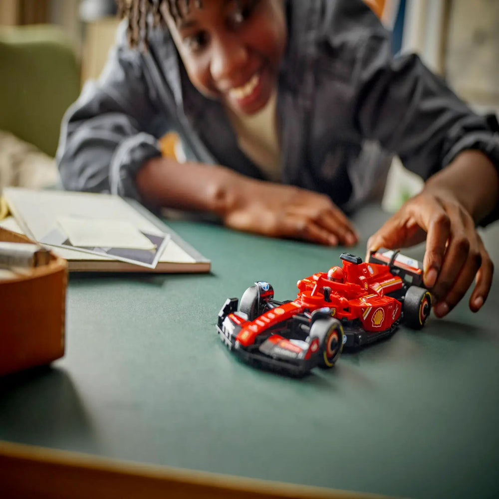 Smiling child playing with red Speed Champions collectible LEGO car Ahmedabad Gujarat online India . Closeup of toy race car