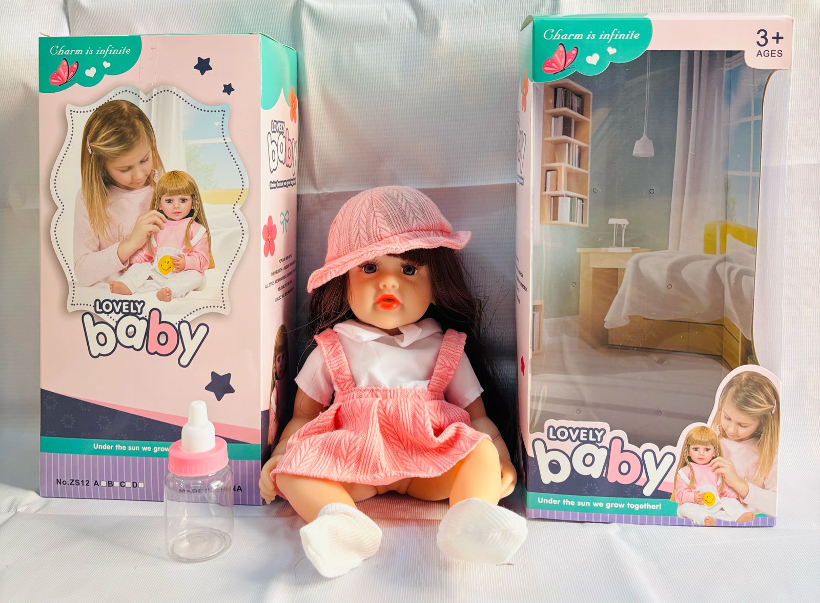 realistic baby doll with accessories silicone real Doll Ahmedabad . Pink dress hat bottle and box
