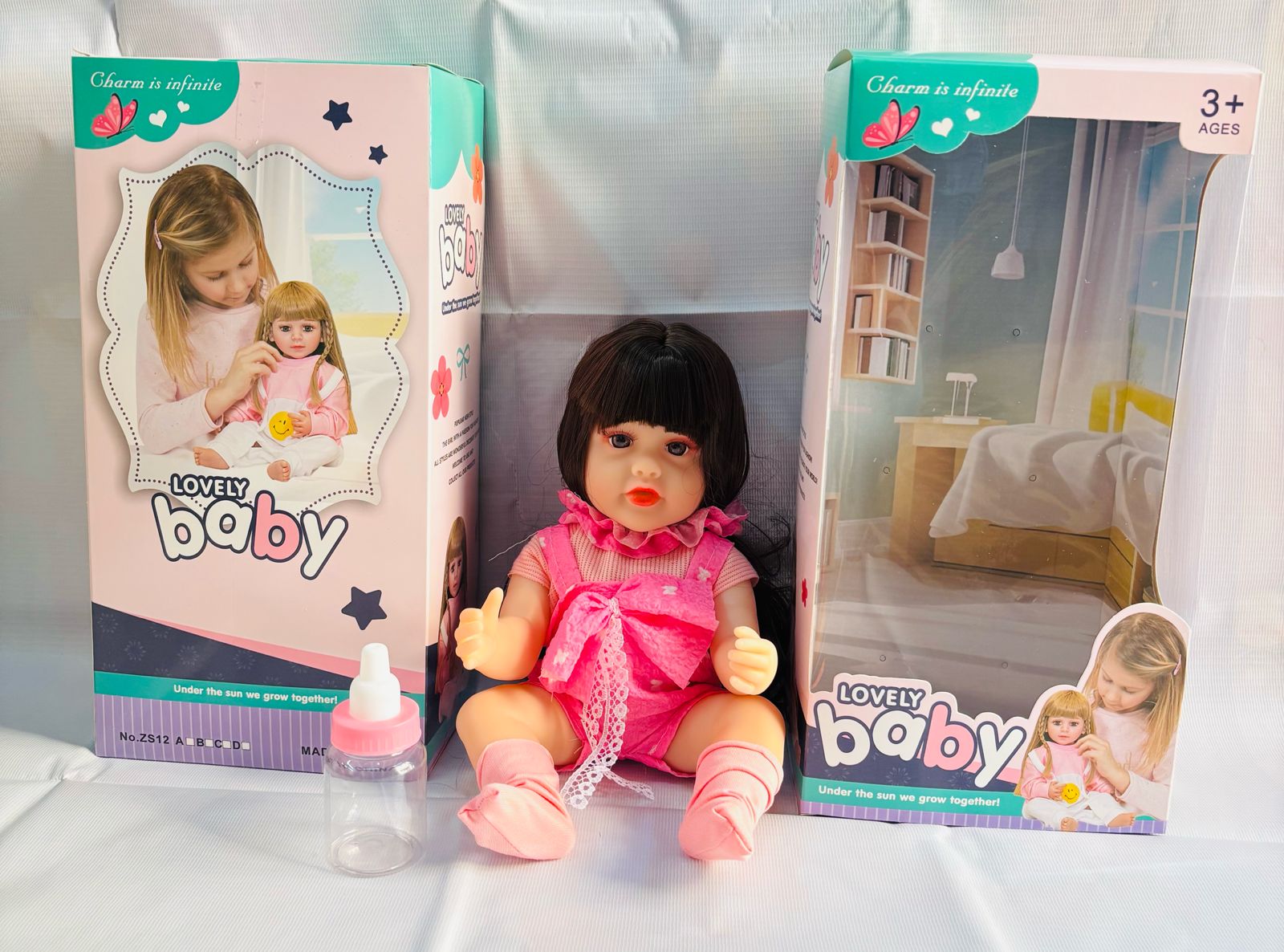 realistic baby doll with accessories silicone real Doll Ahmedabad . lifelike silicone baby in pink outfit with bottle and packaging