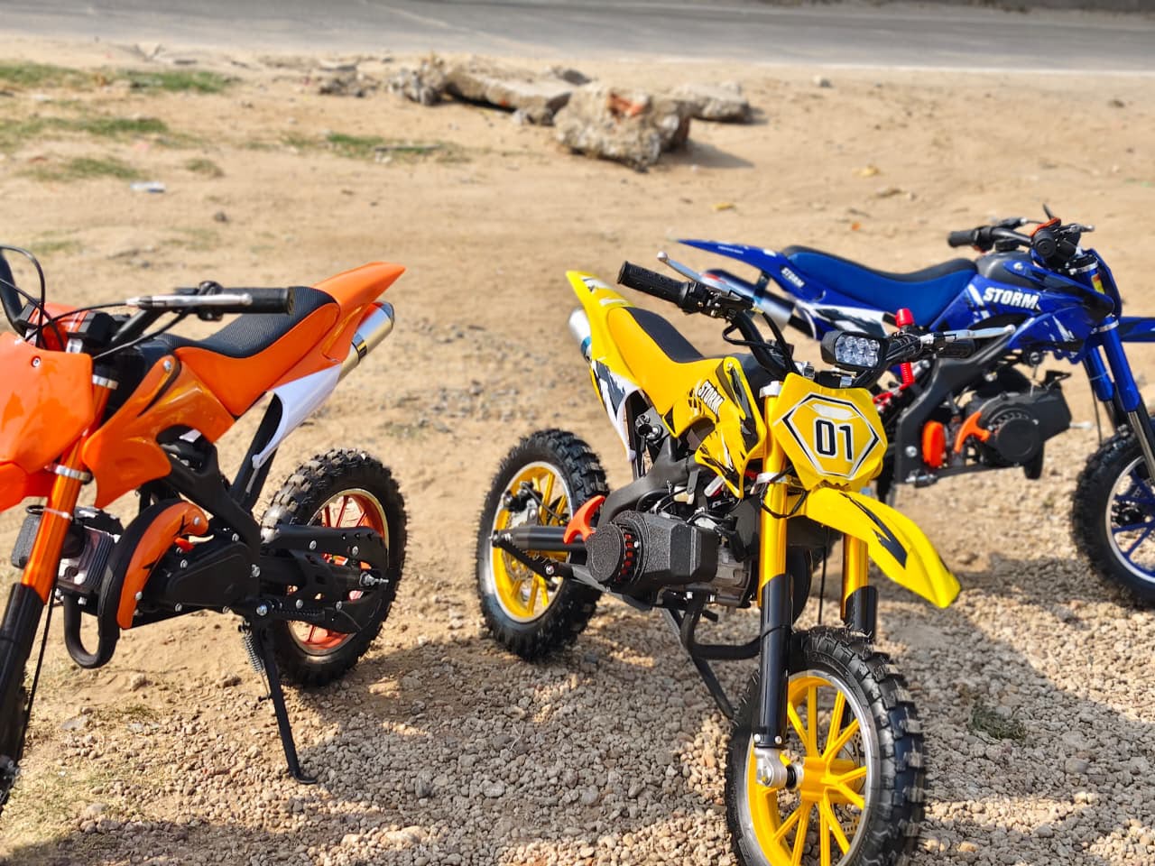 Three colorful Moto dirt bike dirt bike 50cc petrol bike for kids in Ahmedabad, side view, ideal for outdoor adventures
