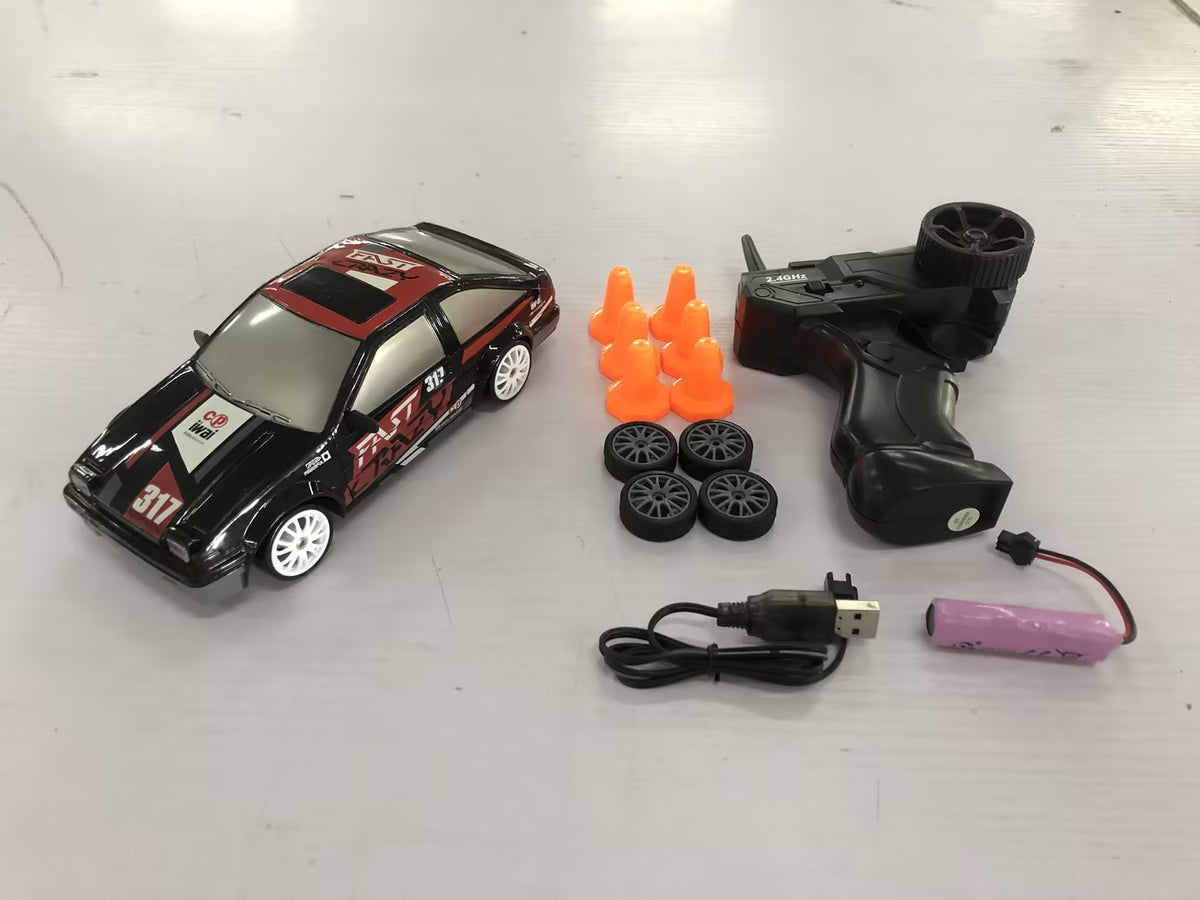 Black remote control car with remote, accessories, and racing cones for fun outdoor play