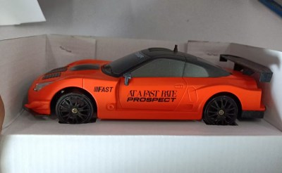 Orange remote control car with remote, side view, perfect for racing fun and outdoor play