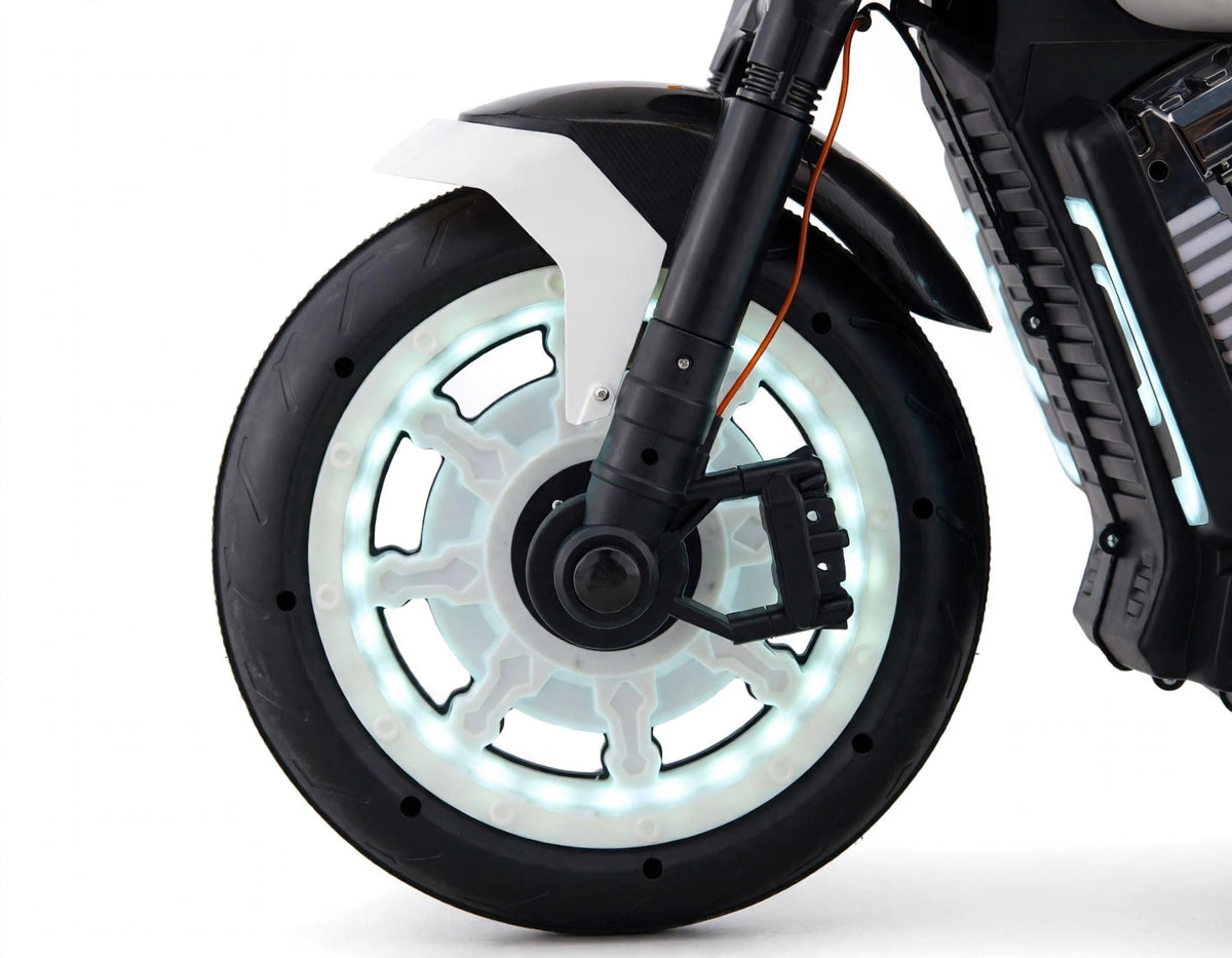 Close-up of the illuminated wheel of a Jumbo size kids electric rechargeable ride on bike harley model at Sam's Toy Ahmedabad