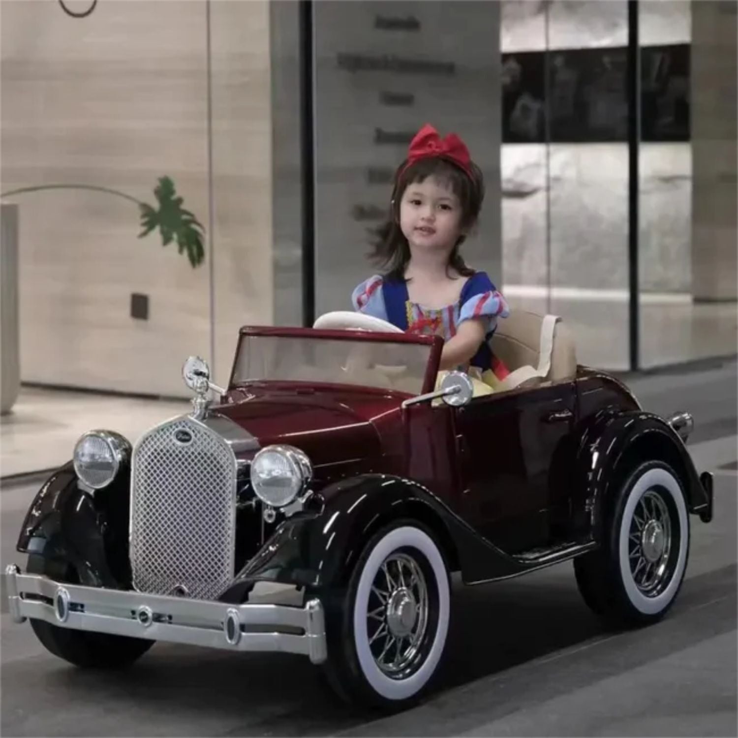 Young girl in maroon vintage electric car Rolls Royce vintage ride on car for kids Ahmedabad Gujarat Online India