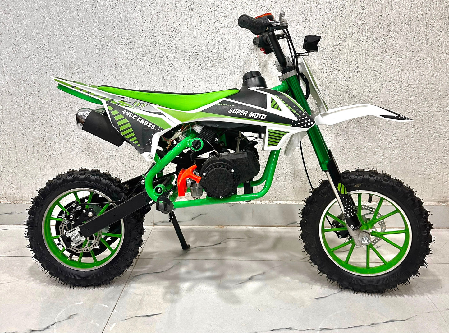 Green and white 49cc dirt bike in Ahmedabad by Sam's Toy World, side view, ideal for young riders