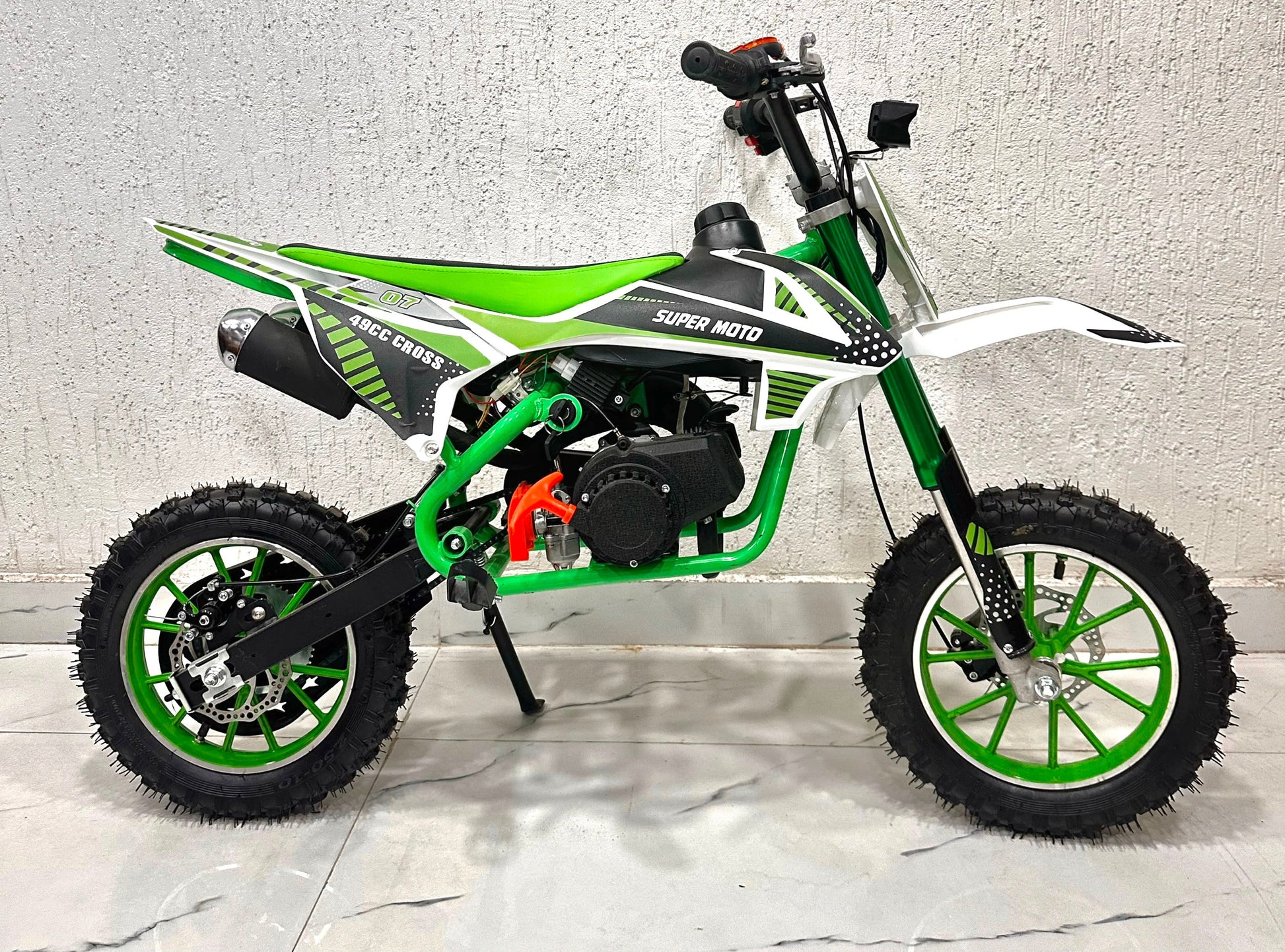 Green and white 49cc dirt bike in Ahmedabad by Sam's Toy World, side view, ideal for young riders