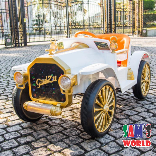 White and gold vintage Mercedes ride on car for kids battery operated in Gujarat with orange seat and cobblestone background
