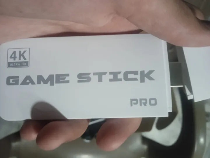 White 4K Ultra HD Game Stick Pro, held in hand, designed for gaming on TV with steam video game console